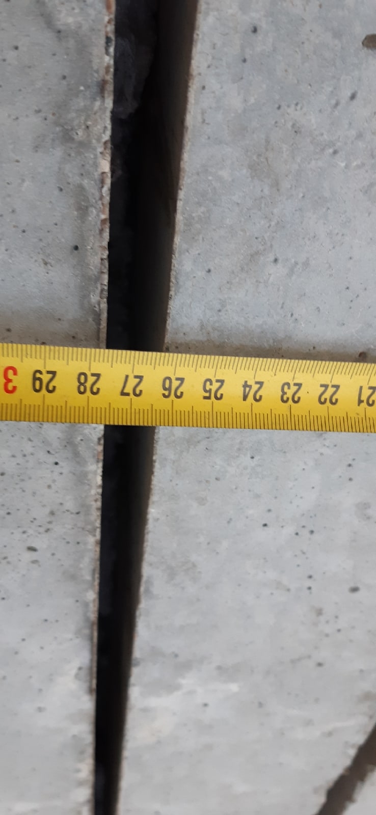 Измерение ширины вертикального зазора между бетонными элементами в кладовке